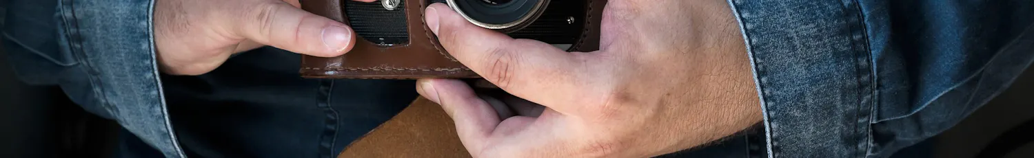 Mann holder filmkamera på magen mens han bruker lyset til å eksponere bildet sitt